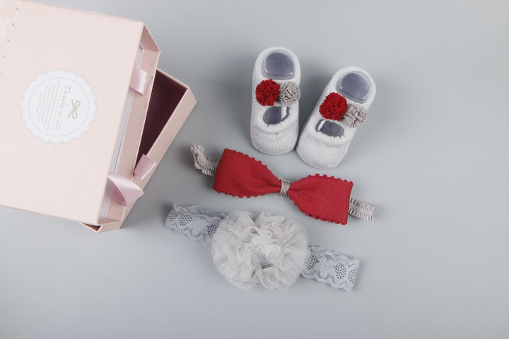 Uudet vauvan hiuslisävarusteiden sukat ja kengät asetettu laatikko