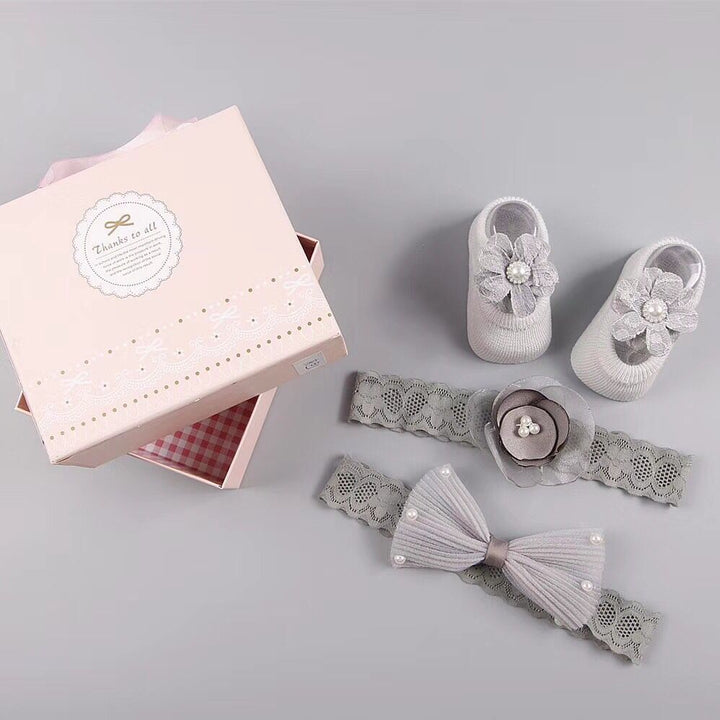 Uudet vauvan hiuslisävarusteiden sukat ja kengät asetettu laatikko