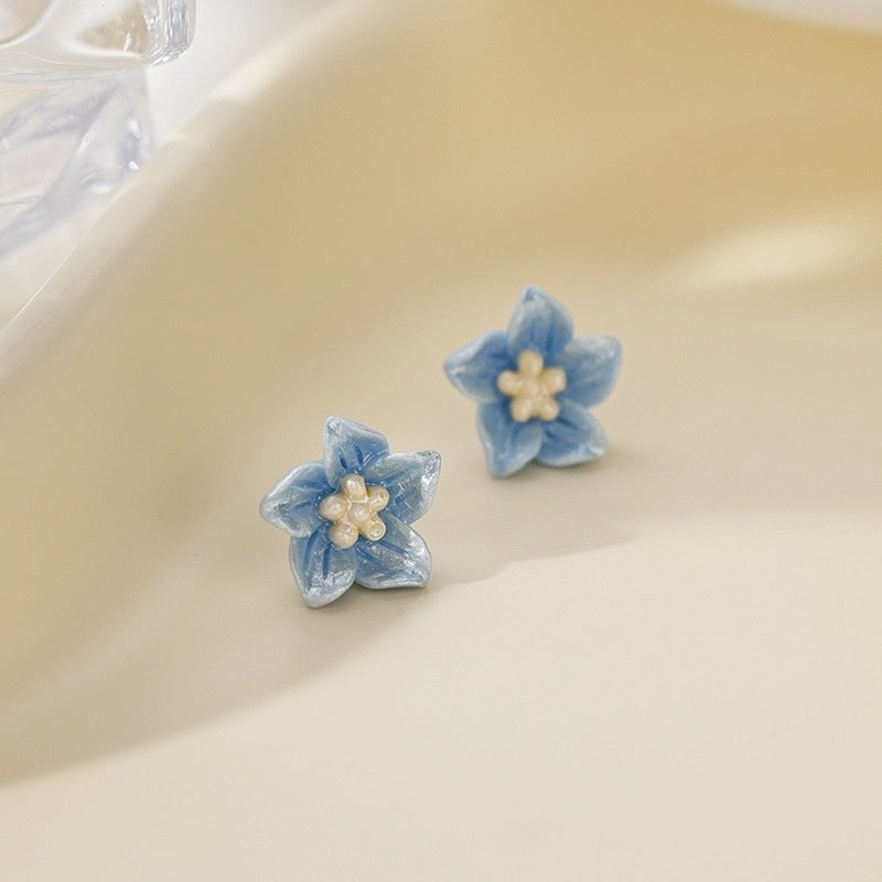 De blå blomma -örhängen är känsliga och små