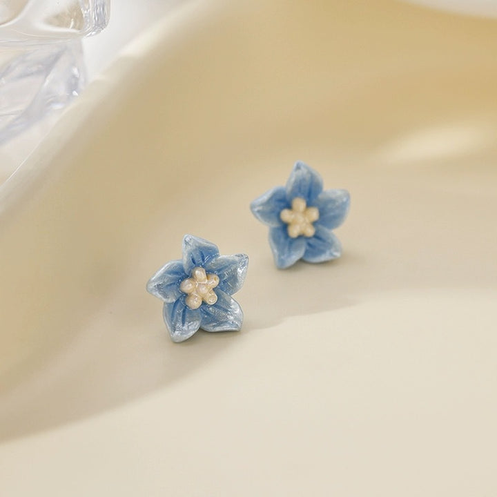 Die blauen Blumenstollenohrringe sind zart und klein
