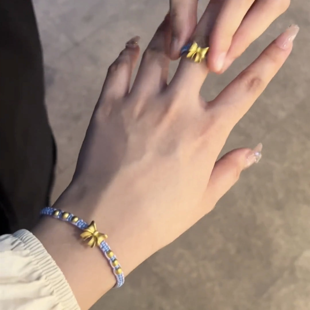 Bracelet à arc anneau bleu à la main de la femme faite